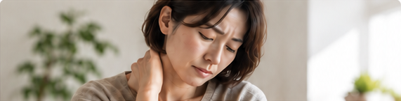 首に手を添え、不調を感じている女性